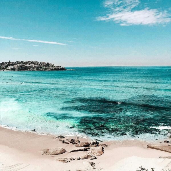 Beach with bright blue water and a few rocks on the shore